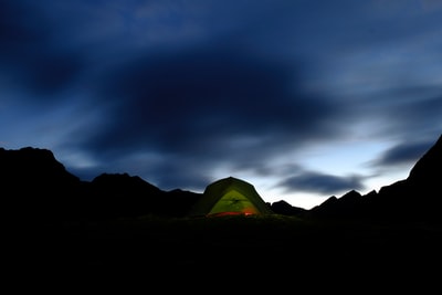 绿色的帐篷在布朗领域下灰色的云层
